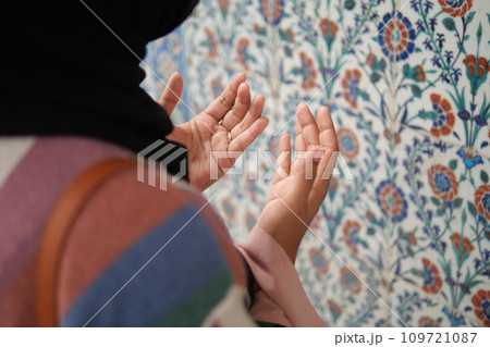 Muslim young woman in hijab is praying in mosque. 109721087