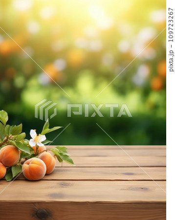 Wooden table top with apricots on blur background with apricot orchard 109723267
