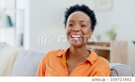Portrait, funny and a black woman laughing on a sofa in the living room of her home to relax on the weekend. Face, smile and comedy with a happy young person in her apartment to joke for humor 109723902