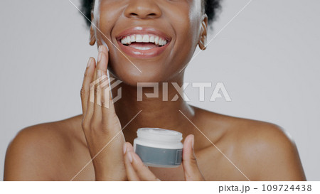 Black Woman, face cream and skincare with beauty, facial and cosmetic product in container, studio background and smile. Happy, female and healthy skin with moisturizer, cosmetology and dermatology 109724438