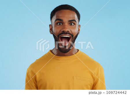Wow and excited black man in studio isolated on a blue background mockup space. Portrait, surprise and happy person in shock for good news, information and winner of bonus promotion 109724442