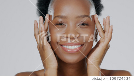 Face touch, skincare and happy black woman in studio isolated on a gray background for dermatology. Portrait, hands and natural beauty cosmetics of model in spa facial treatment, wellness and health Face touch, skincare and happy black woman in studio isolated on a gray background for dermatology. Portrait, hands and natural beauty cosmetics of model in spa facial treatment, wellness and health 109724534