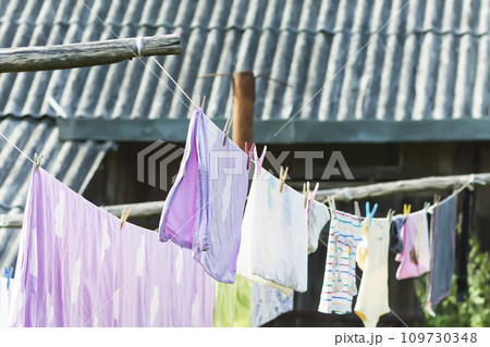 Clean washed laundry hanging on the rope outdoors. 109730348