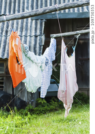 Clean washed laundry hanging on the rope outdoors. Clean washed laundry hanging on the rope outdoors. 109730353
