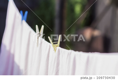Clean washed laundry hanging on the rope outdoors. 109730430