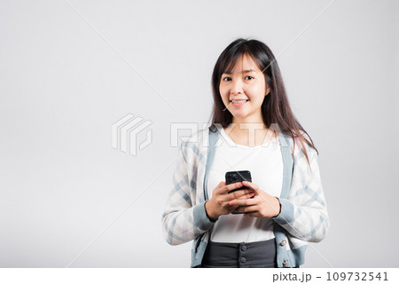 Woman excited read social network feedback on smartphone studio shot isolated white background, young female smiling typing sms message on mobile phone in social media Woman excited read social network feedback on smartphone studio shot isolated white background, young female smiling typing sms message on mobile phone in social media 109732541