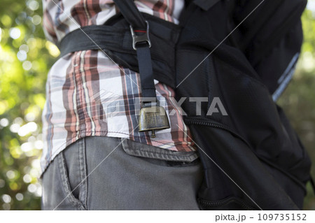 黒いリュックサックに取り付けた熊よけの鈴 109735152