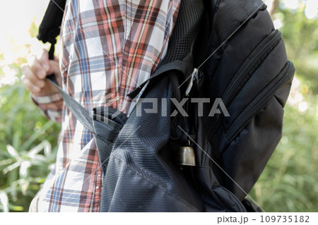 黒いリュックサックに取り付けた熊よけの鈴 109735182