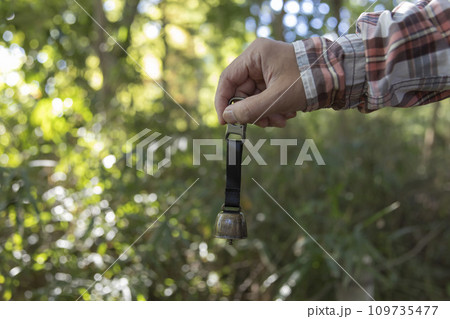 熊よけの鈴を持つ手 109735477