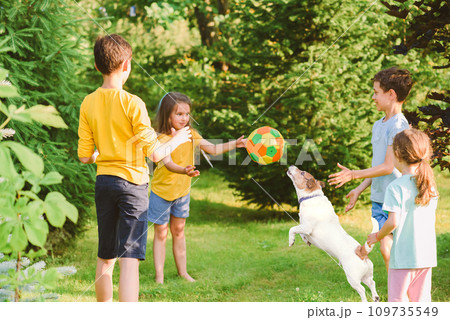 Group of children throw and catch a ball while playing "Monkey in the Middle" game with a dog Group of children throw and catch a ball while playing "Monkey in the Middle" game with a dog 109735549