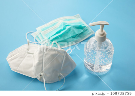 Alcohol sanitizer gel hand wash bottle with N95 Medical face mask on blue background covid-19 Coronavirus prevention concept Alcohol sanitizer gel hand wash bottle with N95 Medical face mask on blue background covid-19 Coronavirus prevention concept 109738759