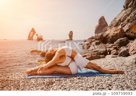 Woman sea yoga. Two happy women practicing yoga on the beach with ocean and rock mountains. Motivation and inspirational fit and exercising. Healthy lifestyle outdoors in nature, fitness concept. 109739093