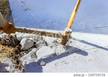 Construction site concrete old driveway demolished by worker hammer Construction site concrete old driveway demolished by worker hammer 109739726
