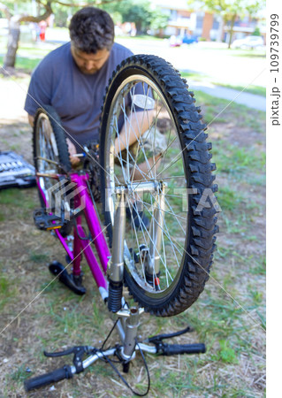 Fixing his bike chain after it broke with repair services 109739799