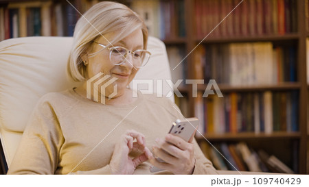Smiling senior woman texting on her smartphone, online communication, the digital age 109740429