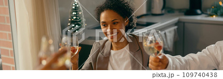 Group of happy friends is drinking cocktails and clinking glasses having holiday dinner party 109740438