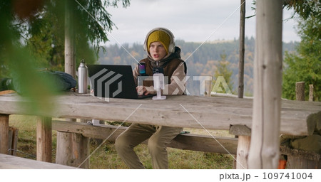 Young boy uses laptop and phone on tripod for streaming 109741004