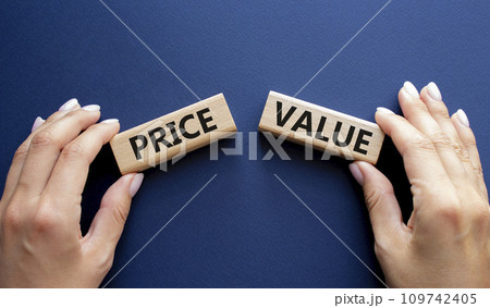 Price and Value symbol. Concept word Price and Value on wooden blocks. Businessman hand. Beautiful deep blue background. Business and Price and Value concept. Copy space 109742405