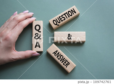 Q and A - Question and Answer. Wooden cubes with words Q and A. Businessman hand. Beautiful grey green background. Business and Q and A concept. Copy space. 109742761