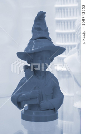 Prototype of art object 3D printed from melted blue plastic. Model of girl in a hat created 3D printer. New innovation modern 3D printing technology. Additive progressive technology 109743352
