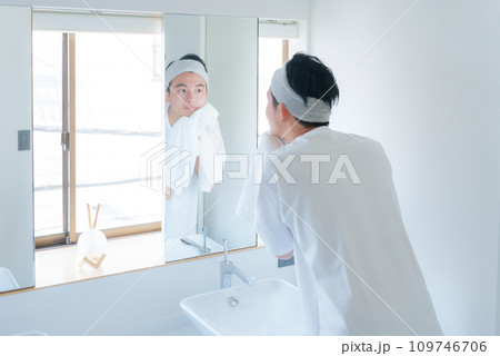 洗顔した顔をタオルで顔を拭く若い男性 109746706