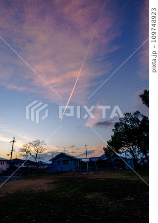 雨の止んだ夕方西の空に広がった夕焼け　大空に広がった茜雲と飛行機雲① 109748923