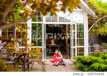Cute and happy brother and sister sitting on the porch of a country house. Cute and happy brother and sister sitting on the porch of a country house. 109750998