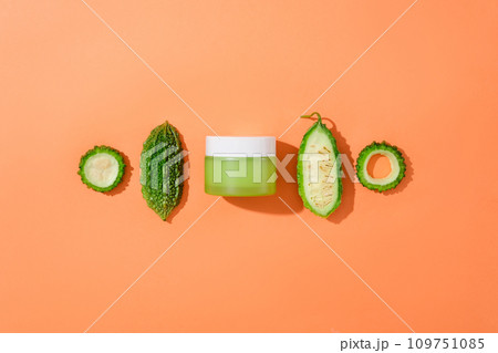 Fresh bitter melon is placed next to an unlabeled cosmetic jar. Bitter melon has a relatively effective sun protection effect for the skin. Mockups for advertising. 109751085