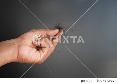 man hold his list hair against black background  109751853