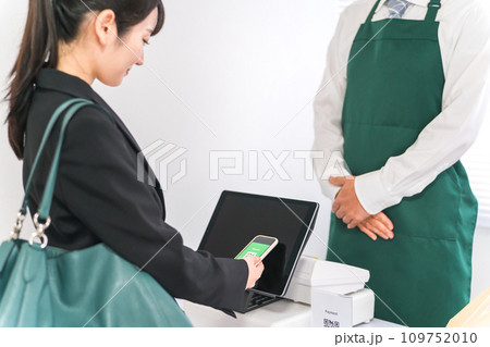 スマホで電子マネーを使って電子決済・モバイル決済・キャッシュレス決済・タッチレス決済をする女性 スマホで電子マネーを使って電子決済・モバイル決済・キャッシュレス決済・タッチレス決済をする女性 109752010