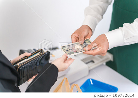 レジスターで現金支払い・会計・精算・するコンビニ・スーパーマーケットの店員 109752014