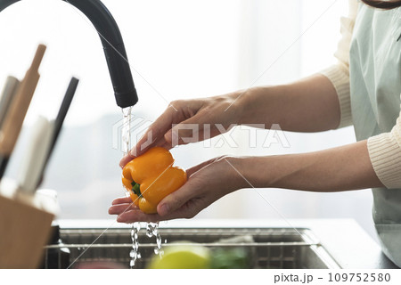 パプリカを水で洗うエプロン姿の女性 パプリカを水で洗うエプロン姿の女性 109752580