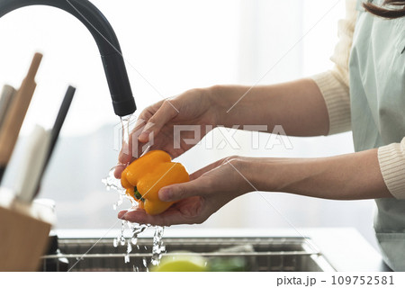 パプリカを水で洗うエプロン姿の女性 パプリカを水で洗うエプロン姿の女性 109752581