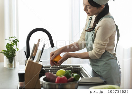 パプリカを水で洗うエプロン姿の女性 パプリカを水で洗うエプロン姿の女性 109752625