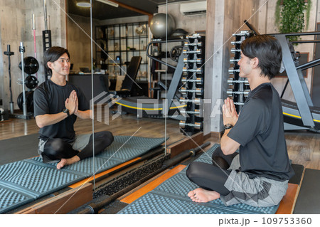 スポーツジムでヨガ・ピラティス・瞑想・マインドフルネスする若いアジア人男性 109753360