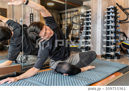 スポーツジムでヨガ・ピラティス・瞑想・マインドフルネスする若いアジア人男性 109753361