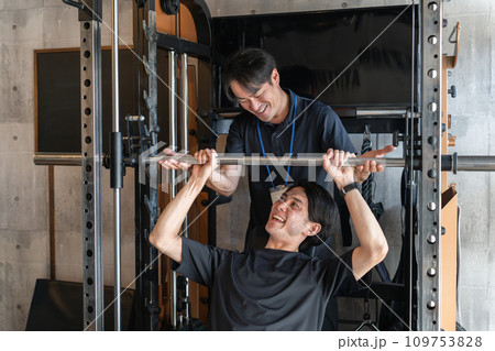 スポーツジムでスポーツトレーナーからパーソナルトレーニングを受ける若いアジア人男性（筋トレ） 109753828