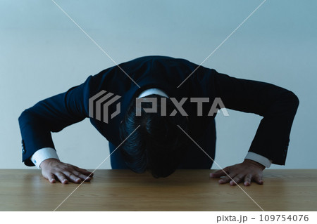 謝罪するスーツ姿の男性 109754076