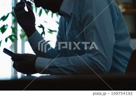 スマートフォンを見てショックを受けるミドル男性 スマートフォンを見てショックを受けるミドル男性 109754192