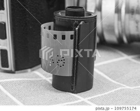 classic 135 film cassette with retro camera background   109755174