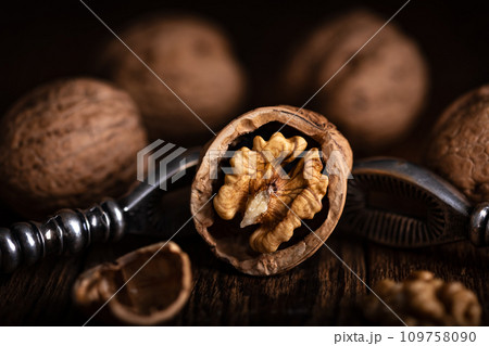 Walnut nut open with a vintage nut cracker close up 109758090