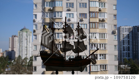Defocused Cityscape Panorama With Wooden Sailing Ship Model On A Foreground Defocused Cityscape Panorama With Wooden Sailing Ship Model On A Foreground 109758120