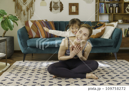 リビングで4歳の女の子とヨガをする若いママ リビングで4歳の女の子とヨガをする若いママ 109758272