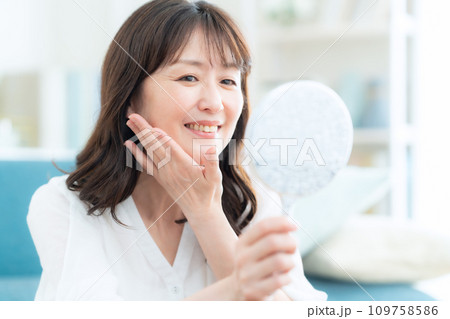 リビングでスキンケアをするミドルの女性 109758586