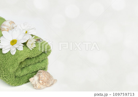 Green towel, shells and flowers on white background Green towel, shells and flowers on white background 109759713