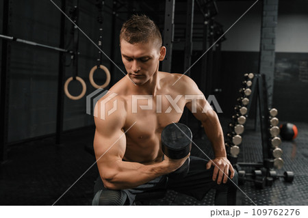 Handsome power athletic man bodybuilder doing exercises 109762276