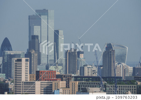 View of famous financial skyscrapers amidst residential district. Modern city with blue sky in background. High angle view of urban development in London. View of famous financial skyscrapers amidst residential district. Modern city with blue sky in background. High angle view of urban development in London. 109763203