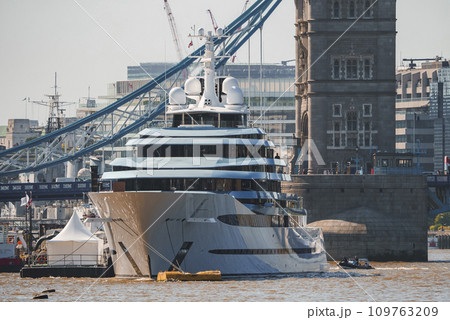 Luxurious cruise ship moored on Thames river. Iconic Tower bridge and buildings with sky in background. Famous tourist attraction in capital city of London. Luxurious cruise ship moored on Thames river. Iconic Tower bridge and buildings with sky in background. Famous tourist attraction in capital city of London. 109763209