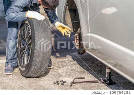 タイヤ交換　ジャッキアップ　夏用タイヤを外す　交換作業　整備士 109764288