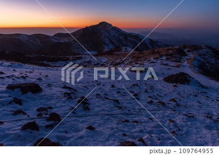 快晴と積雪の冬の久住山山頂からの夕焼け 日本百名山 大分県、九重連山 快晴と積雪の冬の久住山山頂からの夕焼け 日本百名山 大分県、九重連山 109764955